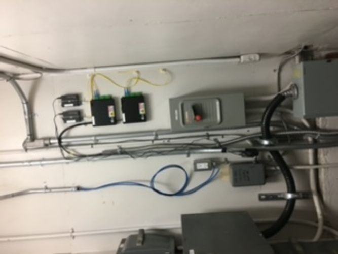 A room with a lot of wires hanging on the wall.